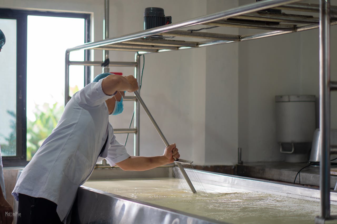 Person stirring cheese in a dairy facility in Bagmati Province, Nepal.
